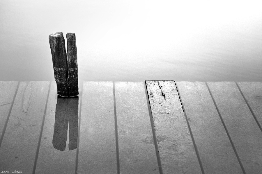 Reflet d'un poteau de ponton inondé