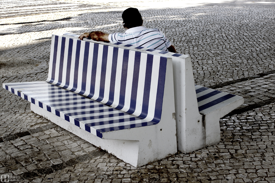 Banc public et homme en rayures