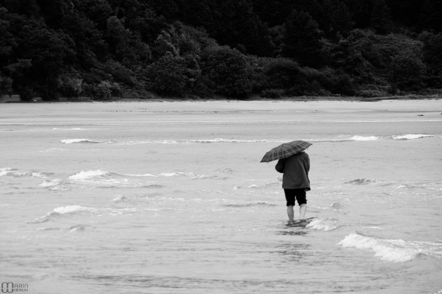 Homme en parapluie en bord de mer