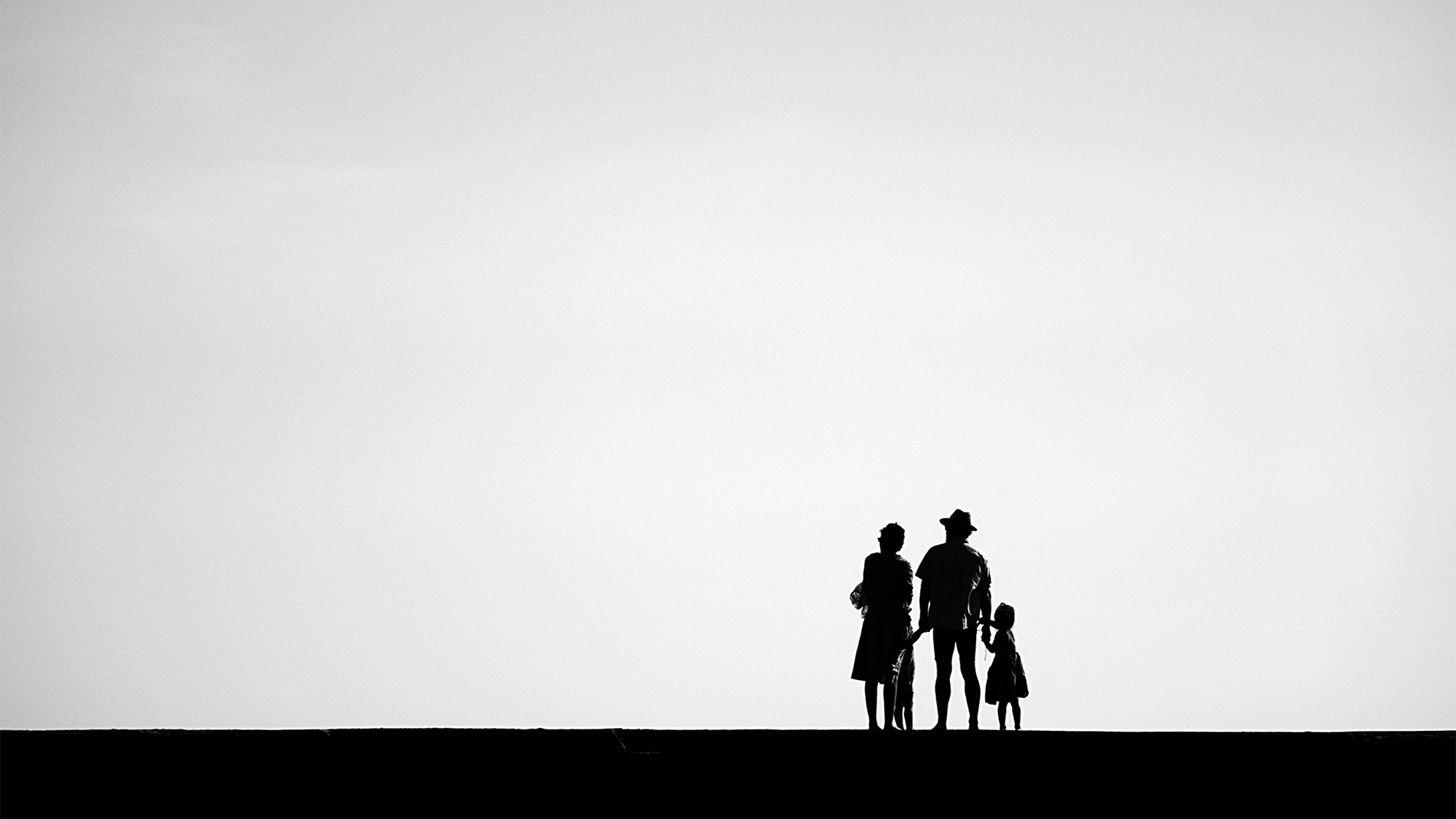 Famille sur une jetée qui regarde l'horizon