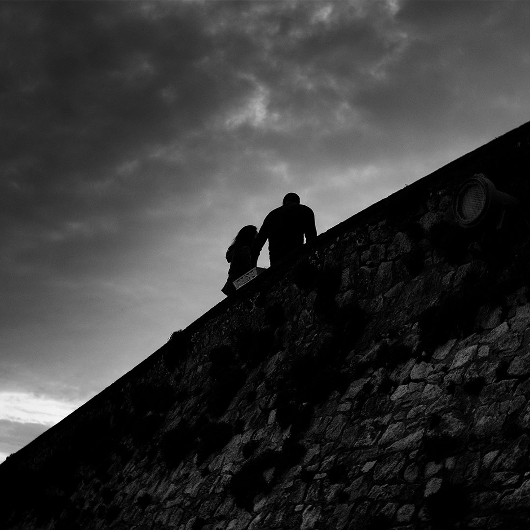 Couple qui discute sous un ciel nuageux en début de soirée - noir et blanc