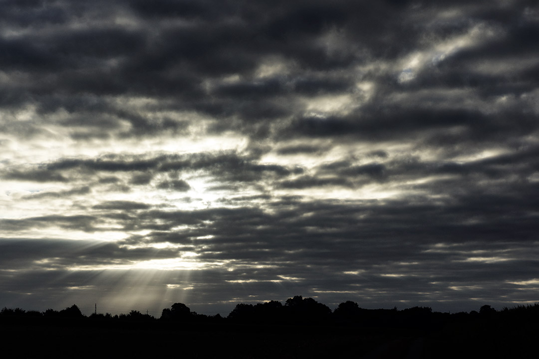 Lever de soleil nuageux : rayons de soleil à travers les nuages