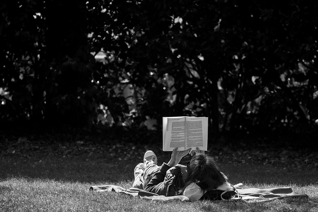 Pause lecture, allongée sur la pelouse d'un jardin public