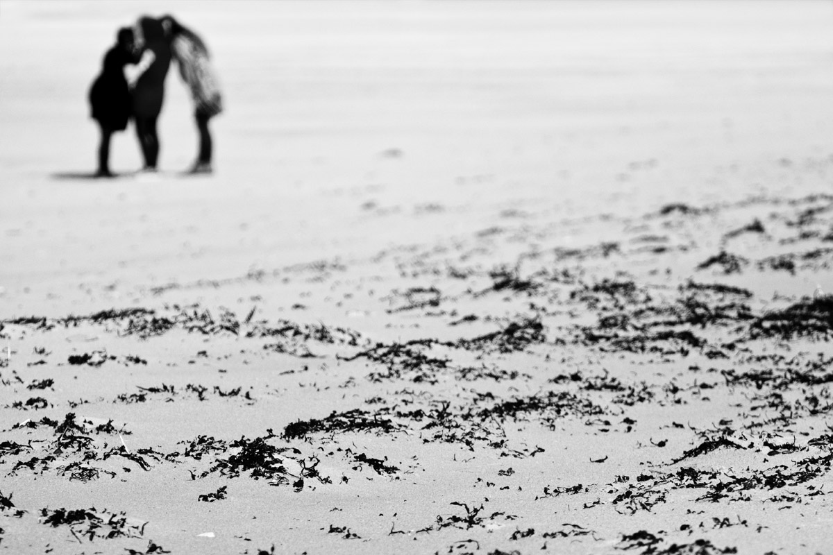 Sable et algues sèches devant trois femmes en toute confidence