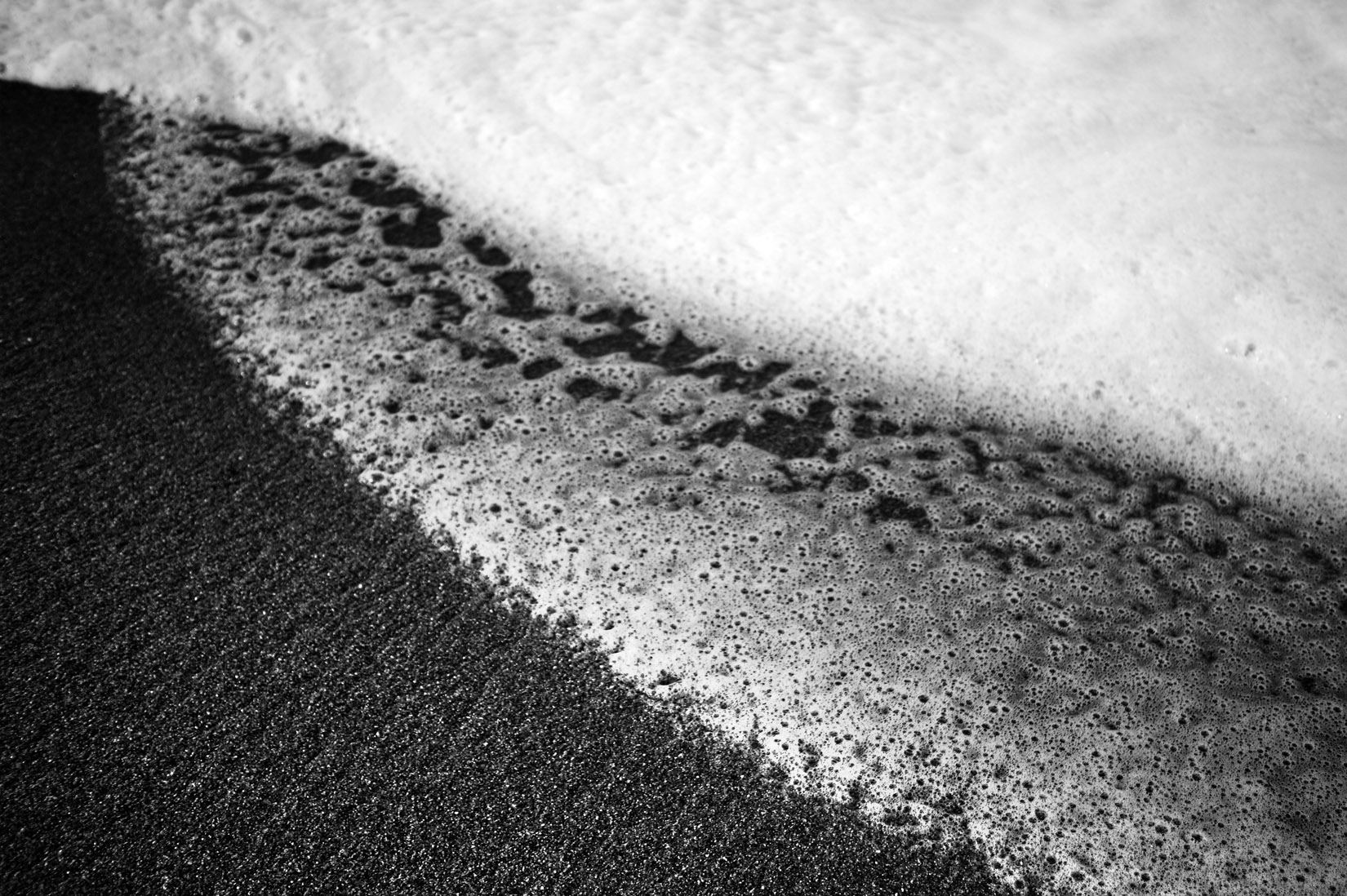 Ecume de vague sur sable de plage - noir et blanc