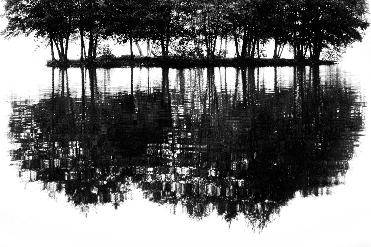 Reflet d'un îlot sur l'eau d'un étang