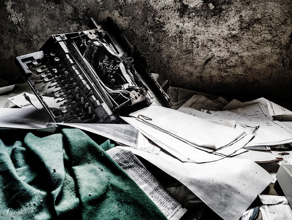 Machine à écrire mécanique abandonnée sur son lit de factures