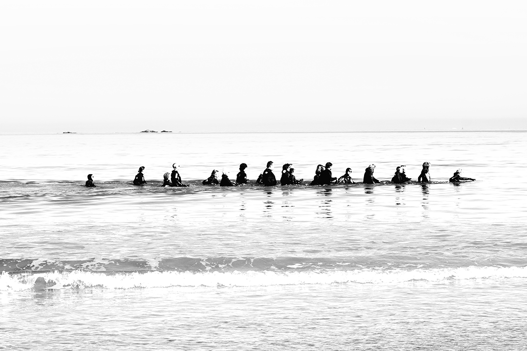 Procession de marcheurs en combinaison dans la baie de Saint-Malo